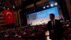 A security personnel stands guard as Turkey's Prime Minister and presidential candidate Tayyip Erdogan addresses the audience during a meeting to launch his election campaign, in Istanbul, July 11, 2014.