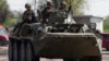 Ukrainian security personnel ride on top of an armored personnel carrier at a checkpoint near the town of Slovyansk in eastern Ukraine, May 4, 2014. 