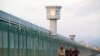 FILE: Workers walk by the perimeter fence of what is officially known as a vocational skills education center in Dabancheng in Xinjiang Uighur Autonomous Region, China, Sept. 4, 2018.