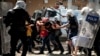 Riot police beat protesters during a demonstration to blame the ruling AK Party government on mining disaster in Izmir, western Turkey, May 15, 2014.