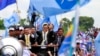 FILE: Sam Rainsy, center, president of Cambodia National Rescue Party (CNRP) greets his supporters together with his party's Vice President Kem Sokha, on Rainsy's left, on his arrival at Phnom Penh International Airport in Phnom Penh, Cambodia, Friday, July 19, 2013. Thousands of cheering supporters greeted Cambodian opposition leader Sam Rainsy as he returned from self-imposed exile Friday to spearhead his party's election campaign against well-entrenched Prime Minister Hun Sen. (AP Photo/Heng Sinith)