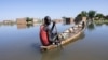 Un homme navigue sur une pirogue entre les maisons du quartier Tougoude, au sud-est du 9ème arrondissement de Ndjamena, inondé par le fleuve Logone, au Tchad le 8 octobre 2024. 