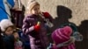 FILE - Children of internally displaced Ukrainian people, who abandoned their homes in Donetsk, play with donated toys during a food distribution drive in central Kyiv, Oct. 25, 2014.
