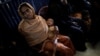 A Rohingya refugee waits for her baby to be examined by doctors at the UNICEF health center at the Kutupalong refugee camp near Cox's Bazar, Bangladesh, Dec. 12, 2017. 