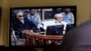 FILE - Khieu Samphan, second from right, former Khmer Rouge head of state, and Noun Chea, left, who was the Khmer Rouge's chief ideologist and No. 2 leader, are seen on a screen at the court's press center of the U.N.-backed war crimes tribunal in Phnom Penh, Cambodia, Aug. 7, 2014. 