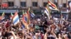 In this photo released by Suwayda24, people stage a protest as they wave the Druze flags in the southern city of Sweida, Syria, Sept. 1, 2023. The protests in the Druze-majority city have been ongoing for nearly two weeks.