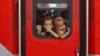 FILE - In this May 30, 2020 photo, Indian migrant worker's children peer out from the window of their train in Prayagraj, India, as they return to villages.
