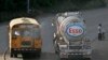 Un autobús público pasa por un camión de distribución de gasolina propiedad de Esso Standard Oil cuando sale de una refinería en Managua, el jueves 6 de diciembre de 2007. 