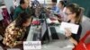 Locals, left, sit for registering their names during a voter registration process of the National Election Committee (NEC) in Phnom Penh, Cambodia, Thursday, Sept. 1, 2016. NEC started its three-month-long voter registration in the day for the next general election scheduled for July 2018. (AP Photo/Heng Sinith)