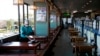 A server with a mask cleans a table at a restaurant in Fujisawa, Japan, Thursday, Feb. 27, 2020. According to local businesses in the area, the number of visitors has dropped significantly since the outbreak of COVID-19. (AP Photo/Jae C. Hong)