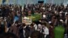 FILE - Afghan men attend a funeral ceremony of an International Committee of the Red Cross (ICRC) employee, who was killed by gunmen in Mazar-i-Sharif, Afghanistan, Feb. 9, 2017.