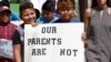 FILE - Children of mainly Latino immigrant parents hold signs in support of them and those individuals picked up during an immigration raid, during a protest march to the Madison County Courthouse in Canton, Miss., Aug. 11, 2019.
