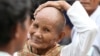 A Cambodian gestures outside the Extraordinary Chambers in the Courts of Cambodia (ECCC) courtroom during the trial of former Khmer Rouge leaders on the outskirts of Phnom Penh Jan. 10, 2012.