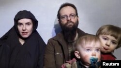 A still image from a video posted by the Taliban on social media, Dec. 19, 2016, shows American Caitlan Coleman speaking next to her Canadian husband, Joshua Boyle, and their two sons. 