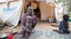 A woman and her children displaced by fighting in South Sudan sit outside her tent at the Kule camp for Internally Displaced People at the Pagak border crossing in Gambella, Ethiopia, July 10, 2014.