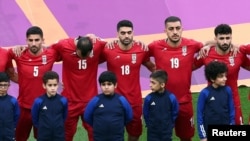 দোহার খলিফা আন্তর্জাতিক স্টেডিয়ামে কাতার ২০২২ বিশ্বকাপের গ্রুপ-বি এর ইংল্যান্ড বনাম ইরান ম্যাচের আগে নীরবে জাতীয় সংগীত শুনছেন ইরানের খেলোয়াড়রা, ২১ নভেম্বর ২০২২।