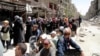 FILE - Residents wait to receive food aid distributed by the U.N. refugee agency at the Palestinian refugee camp of Yarmouk, south of Damascus, Syria, May 2014.