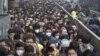 FILE - Morning commuters wait in line at the Tiantongyuan subway station on a smoggy day after the city issued its first ever "red alert" for air pollution, in Beijing, China, Dec. 8, 2015.