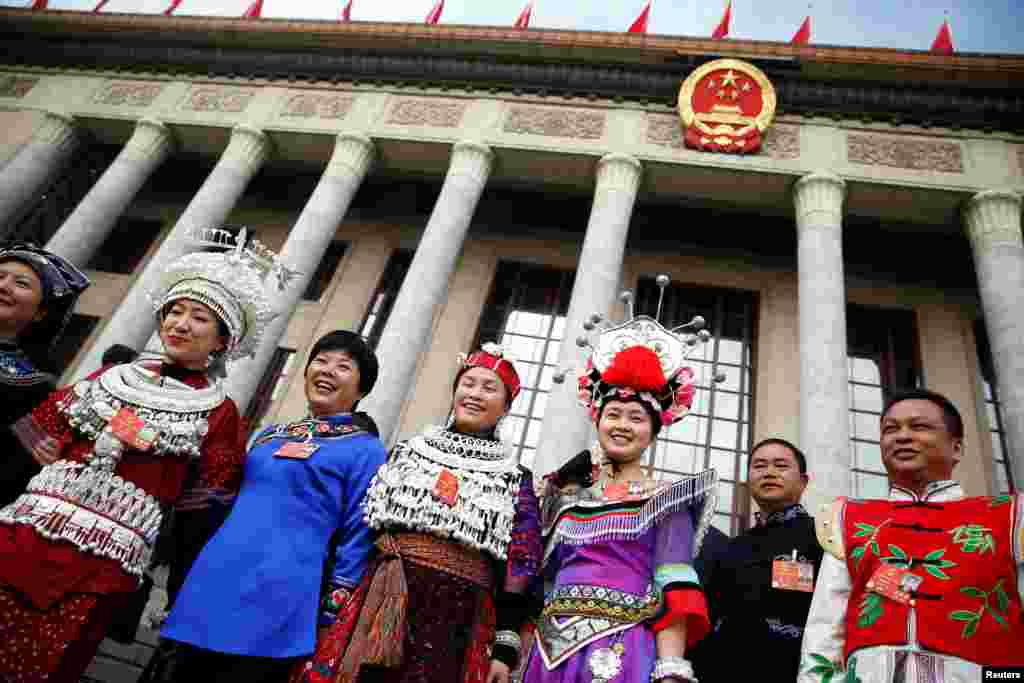 2018年3月5日在北京举行的中国人大开幕会前,穿戴少数民族服饰的代表站在人民大会堂外。今年全国人大和政协中女性代表的比例分别为24.9%和20.39%,双双达到历史新高。然而从未有女性当选中共中央政治局常委。