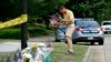 Rich Lindgren, de Virginia Beach, coloca banderas estadounidenses en un monumento improvisado en el borde de un cordón policial frente a un edificio municipal que fue el escenario de un tiroteo.