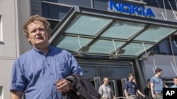 Union steward Jarmo Talvitie talks to media as Nokia employees leave a personnel briefing in Tampere, Finland, June 14, 2012. 