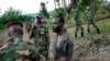 FILE - Congolese M23 rebel fighters detain a man they suspect to be an FDLR (Force Democratique de Liberation du Rwanda) rebel returning from an incursion into Rwanda Near Kibumba, north of Goma, Nov. 27, 2012. 