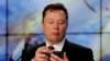 FILE PHOTO: Elon Musk looks at his mobile phone