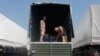 Drivers of a Russian convoy of trucks carrying humanitarian aid for Ukraine show the contents of their truck at a camp near Kamensk-Shakhtinsky, Rostov Region, Aug. 15, 2014. 