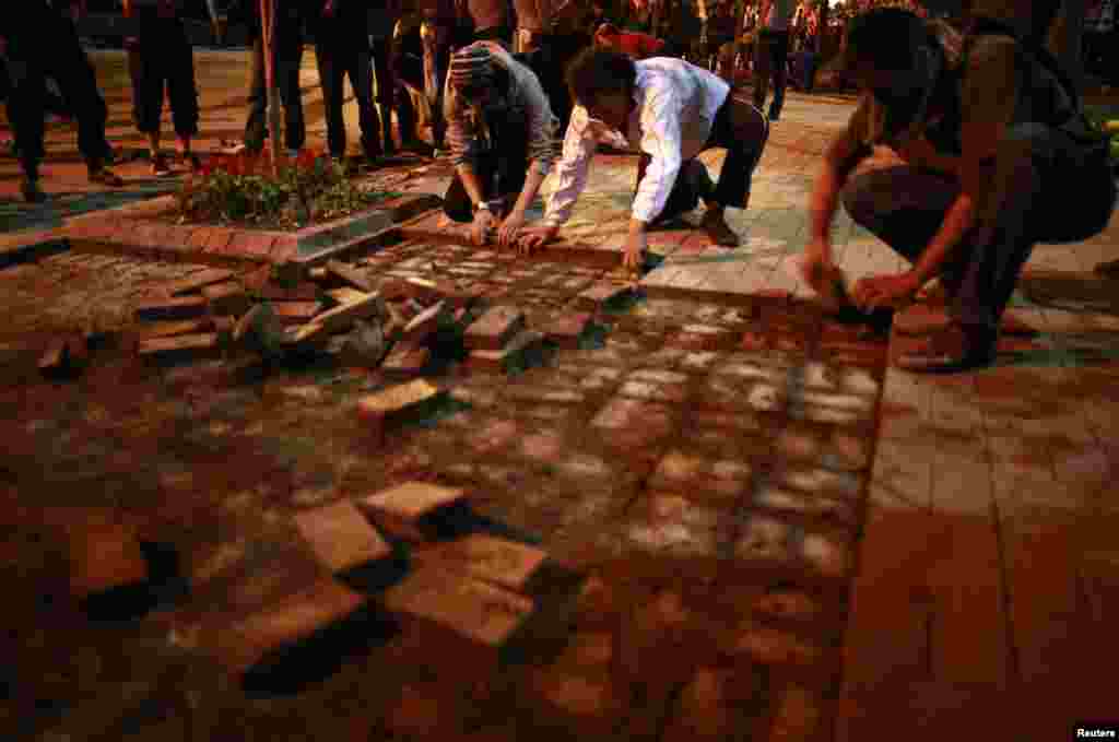 Anti-government protesters remove bricks from a sidewalk to build a barricade in central Ankara, June 9, 2013.