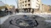 An Egyptian worker checks a hole believed to be caused by a car bombing in the street outside the national security building in the Shubra el-Kheima neighborhood of Cairo, Aug. 20, 2015.