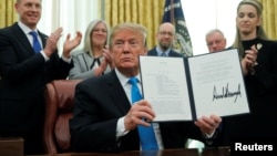 U.S. President Donald Trump displays the "Space Policy Directive 4" after signing the directive to establish a Space Force as the sixth branch of the Armed Forces in the Oval Office at the White House in Washington, Feb. 19, 2019. 
