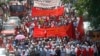 Lebanese leftist activists wave flags as they march during a demonstration to mark Labor Day, or May Day, along a street in Beirut, May 1, 2013.